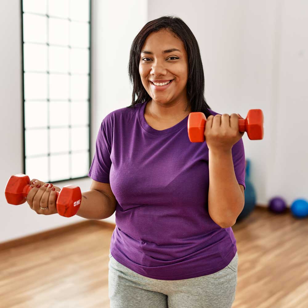 Woman lifting small weights at home